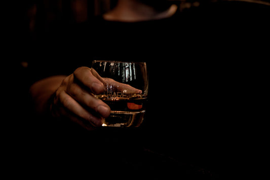 Man holding a glass of whisky.